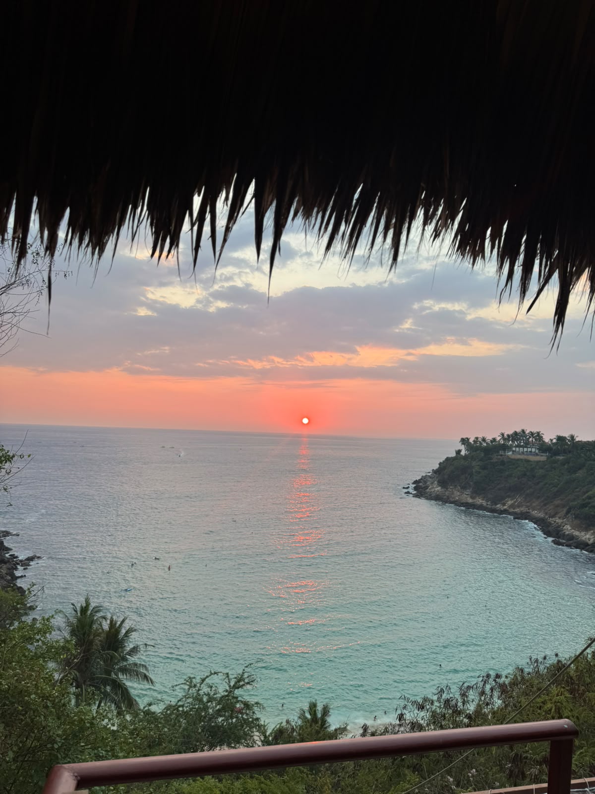 Atardecer sobre la bahía visto desde una palapa
