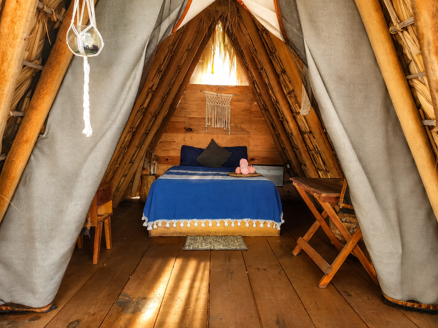 Interior de teepee con cama y luz cálida